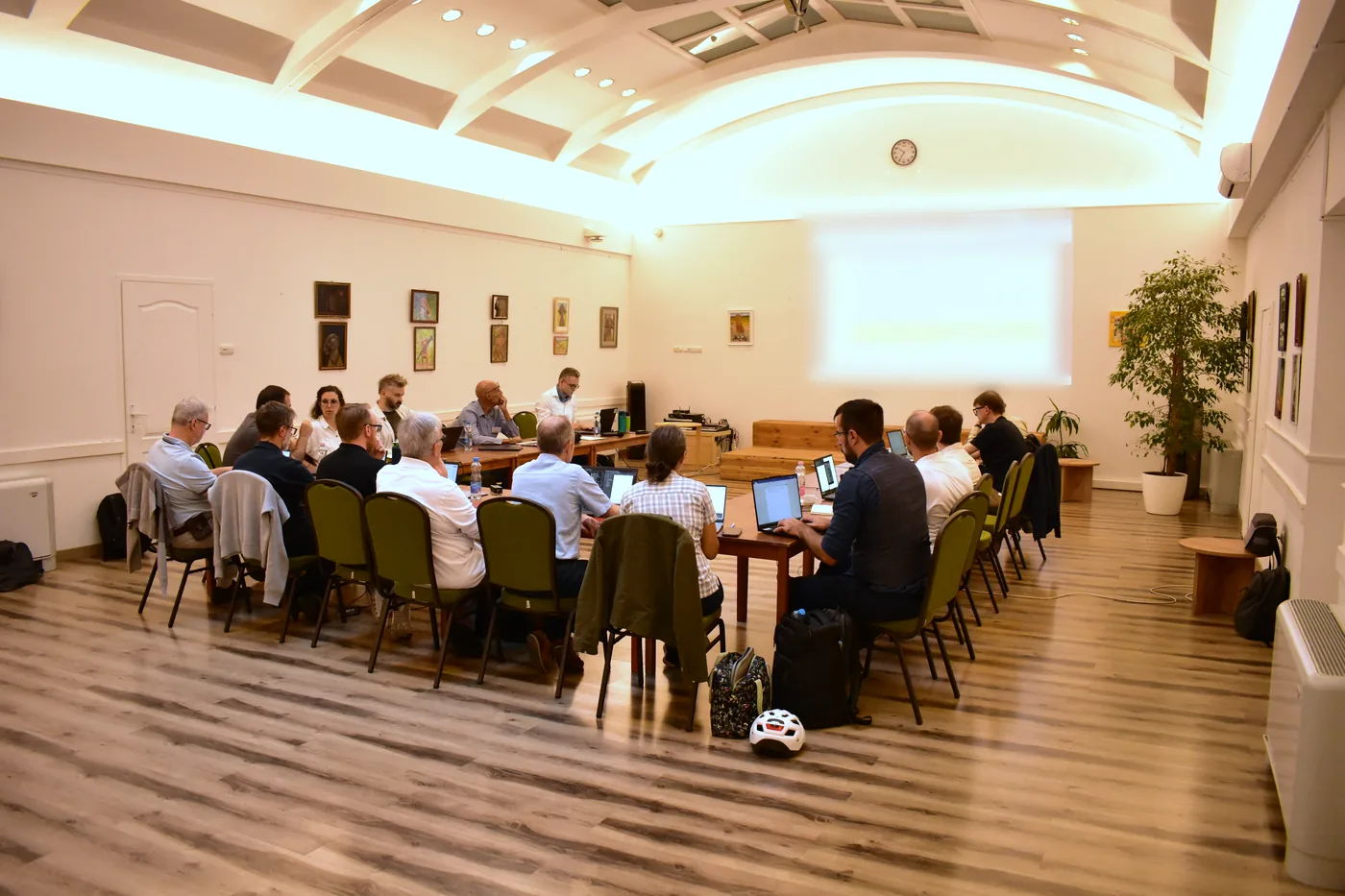 Participants of the 37th VG11 Conference around the meeting table in the hall of the MagNet Community House in Budapest, photographed from a distance